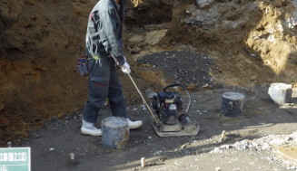 住宅の建設現場で砕石を転圧する様子